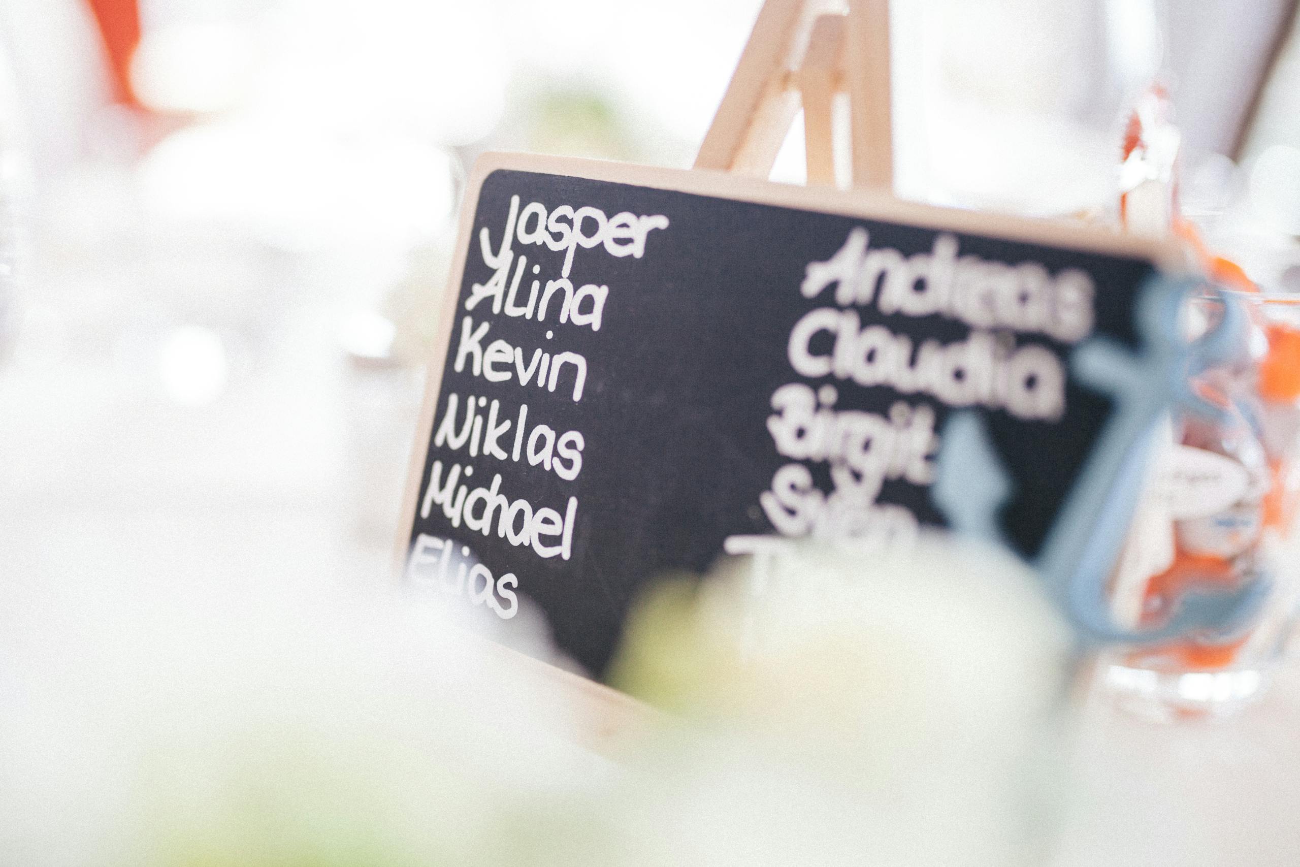 A decorative chalkboard displaying names at a refined indoor gathering.