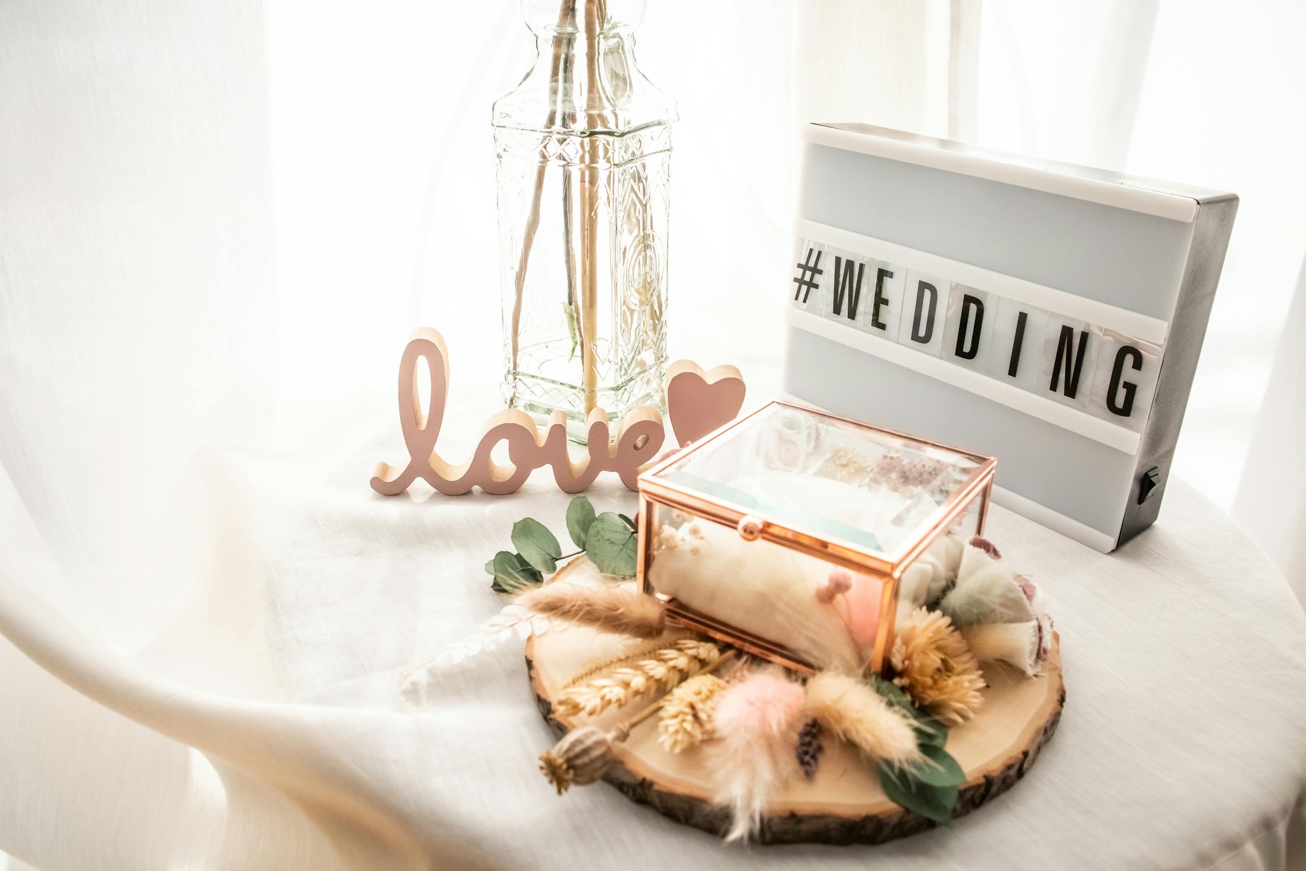 Charming wedding setup featuring a love sign, flowers, and elegant decorations on a table.