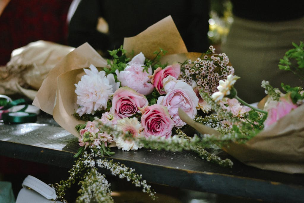 Stunning flower bouquet with pink roses and peonies on display table, perfect for weddings.