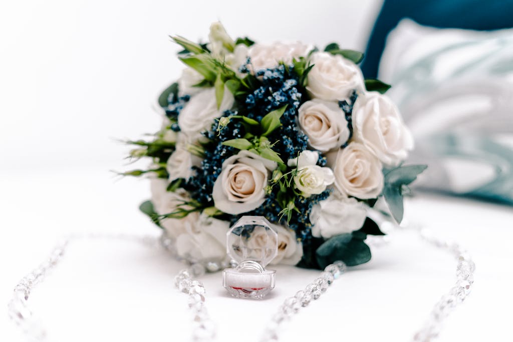 Beautiful bouquet of white roses with an engagement ring, perfect for a wedding theme.